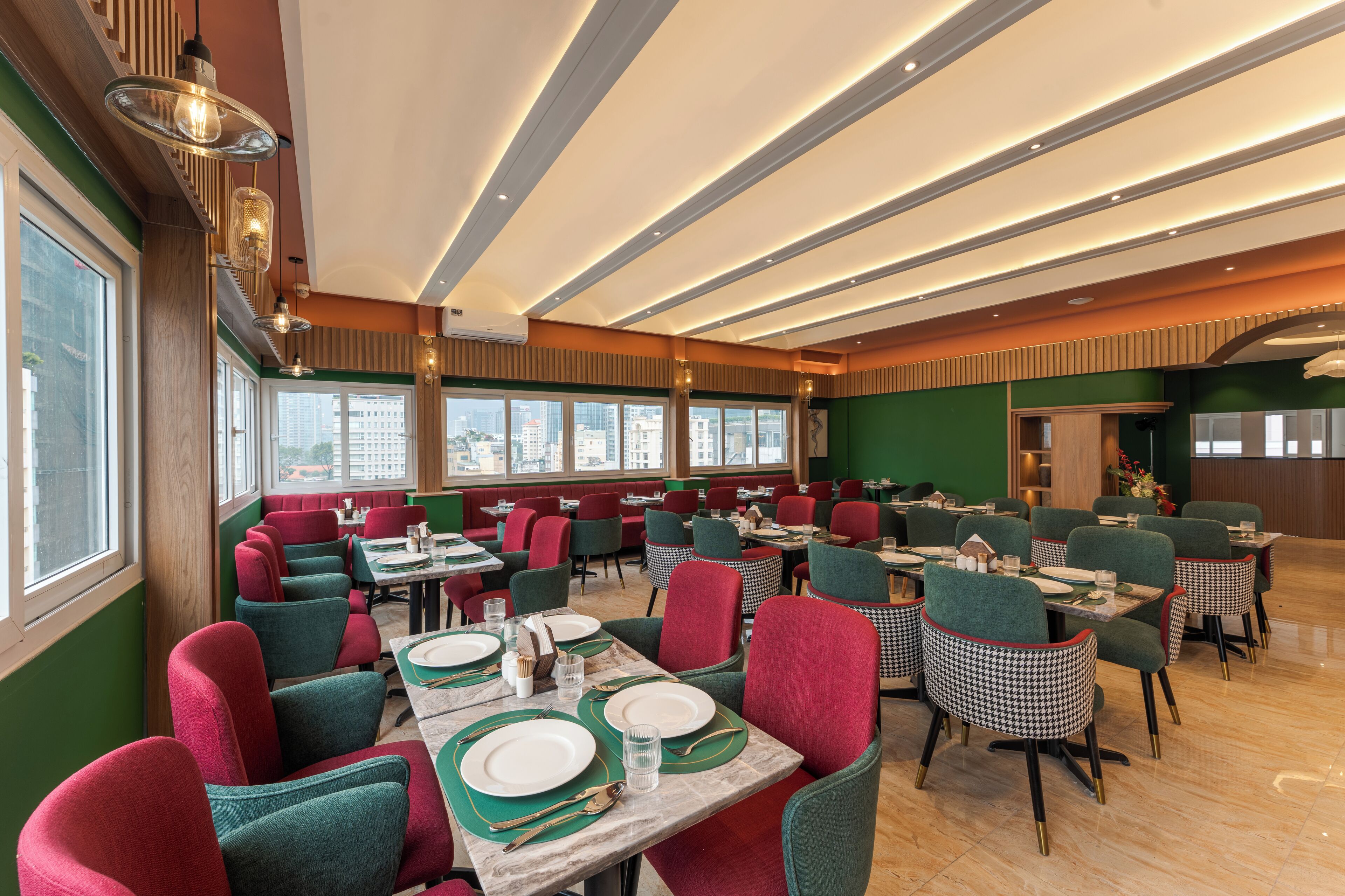 A restaurant with multiple tables and chairs, large windows, and a modern ceiling design.