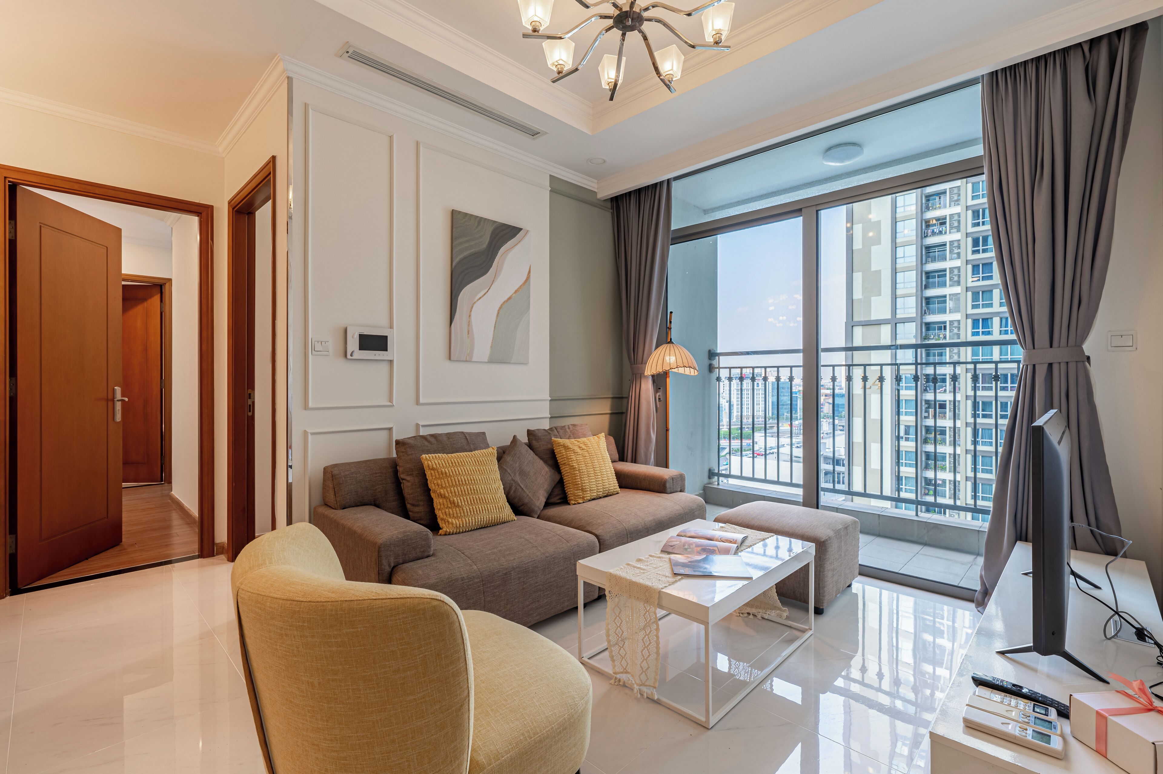 A modern living room with a sofa, armchair, coffee table, and a television.