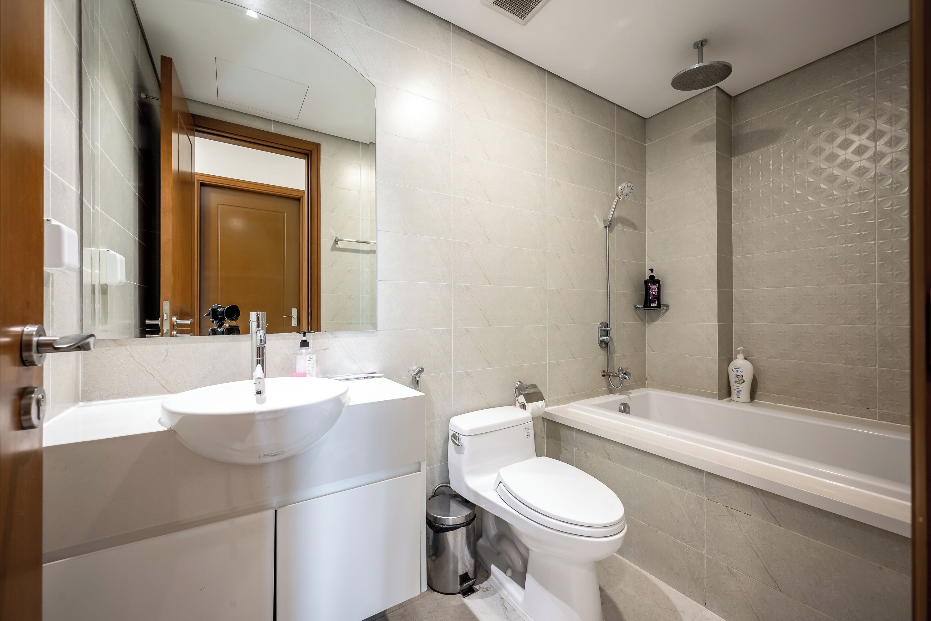 Un baño moderno con lavamanos, inodoro y bañera blancos.