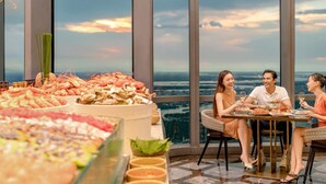 Comedor con vista a la ciudad, exhibición de mariscos y una mesa con tres personas.