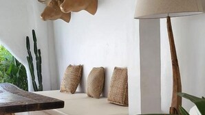 A modern living room with a wooden coffee table, a white sofa with textured cushions, and a wall-mounted bull head sculpture. - Sal Central (Pecatu)