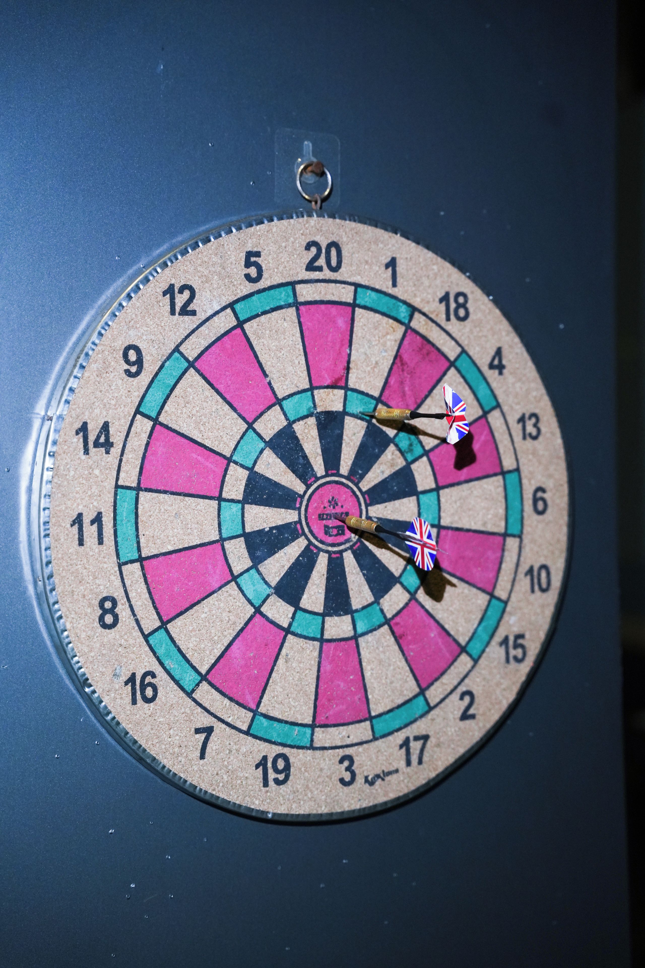 A dartboard with a dart in the center, mounted on a wall.
