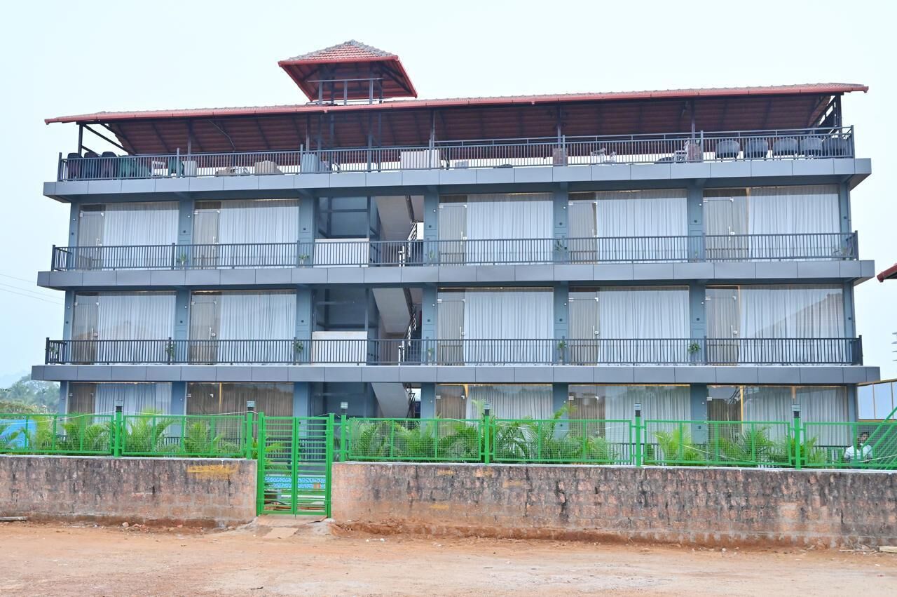 A multi-story building with balconies and a red roof.