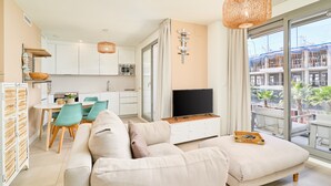 A modern apartment with a living room, dining area, kitchenette, and a balcony with a view of the city. - Apartment 'Sunset Panorama' with Sea View, Wi-Fi and Air Conditioning (El Morche)