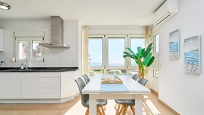 Eine moderne Küche mit weißen Schränken, einer großen Kochinsel und einem Essbereich mit Tisch und Stühlen.
