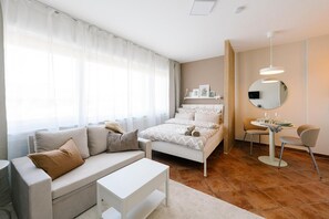 Un dormitorio moderno con una cama, un sofá, una mesa de comedor y una silla.