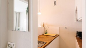 A compact bathroom with a mirror, sink, and a small countertop. - Apartment 'Air Fair' with Wi-Fi (Düsseldorf)