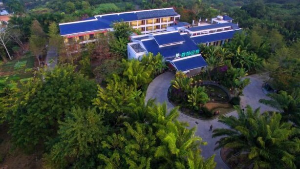 A hotel with a modern design, surrounded by lush greenery and a well-maintained garden.