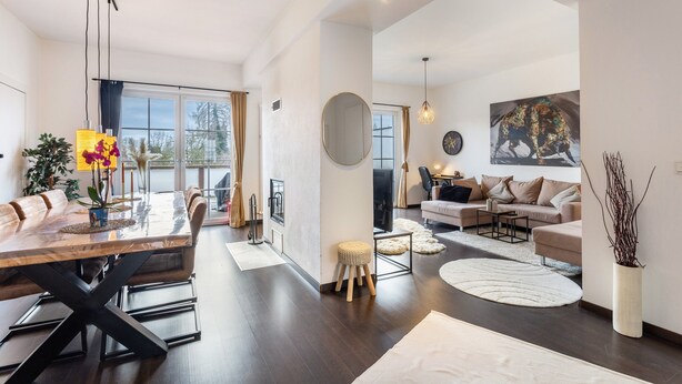 A spacious living area with a dining table, sofas, and a large window. - Exclusive Loft with Fireplace, Private Sun Balcony & Wi-Fi in Bad Salzuflen (Bad Salzuflen)