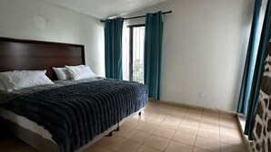 A bedroom with a bed, a window with curtains, and a tiled floor. - House for rent Cuernavaca Morelos by day or weekend (Cuernavaca)