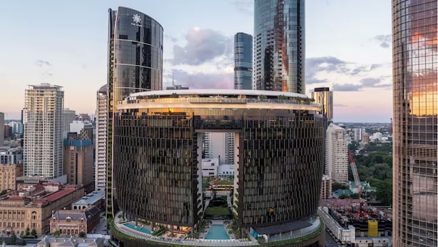 A modern building with a circular design, featuring a rooftop pool and a central courtyard. - Queen's Wharf 1B+Study · City Breeze & Views (Brisbane City)