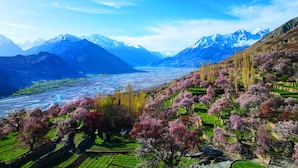 A mountainous landscape with terraced fields and a river.