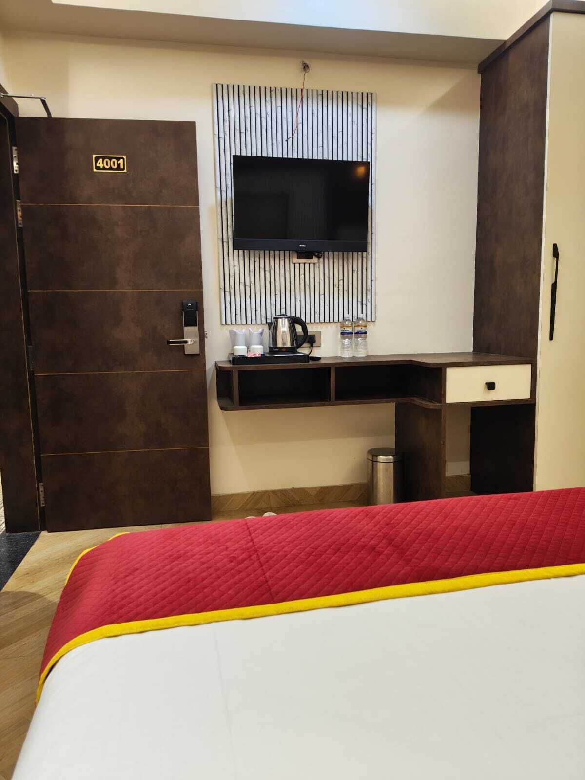 A hotel room with a bed, a desk, a TV mounted on the wall, and a door labeled "4001".