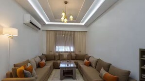 A modern living room with a sectional sofa, a coffee table, and a patterned rug.