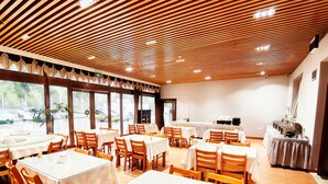 A restaurant with multiple tables and chairs, large windows, and a wooden ceiling. - Gelin Haotai Zhixuan Jiudian (Shunyi)