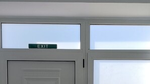 A double door with an 'EXIT' sign above it, a sliding glass door, and a tiled floor. - Aenaon Corfu Luxury Apartments 01 - Apollo Apt (Corfu)