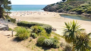 A beach with people, a clear sky, and a rocky hillside. - -Alizée- Charming house in Névez (Névez)