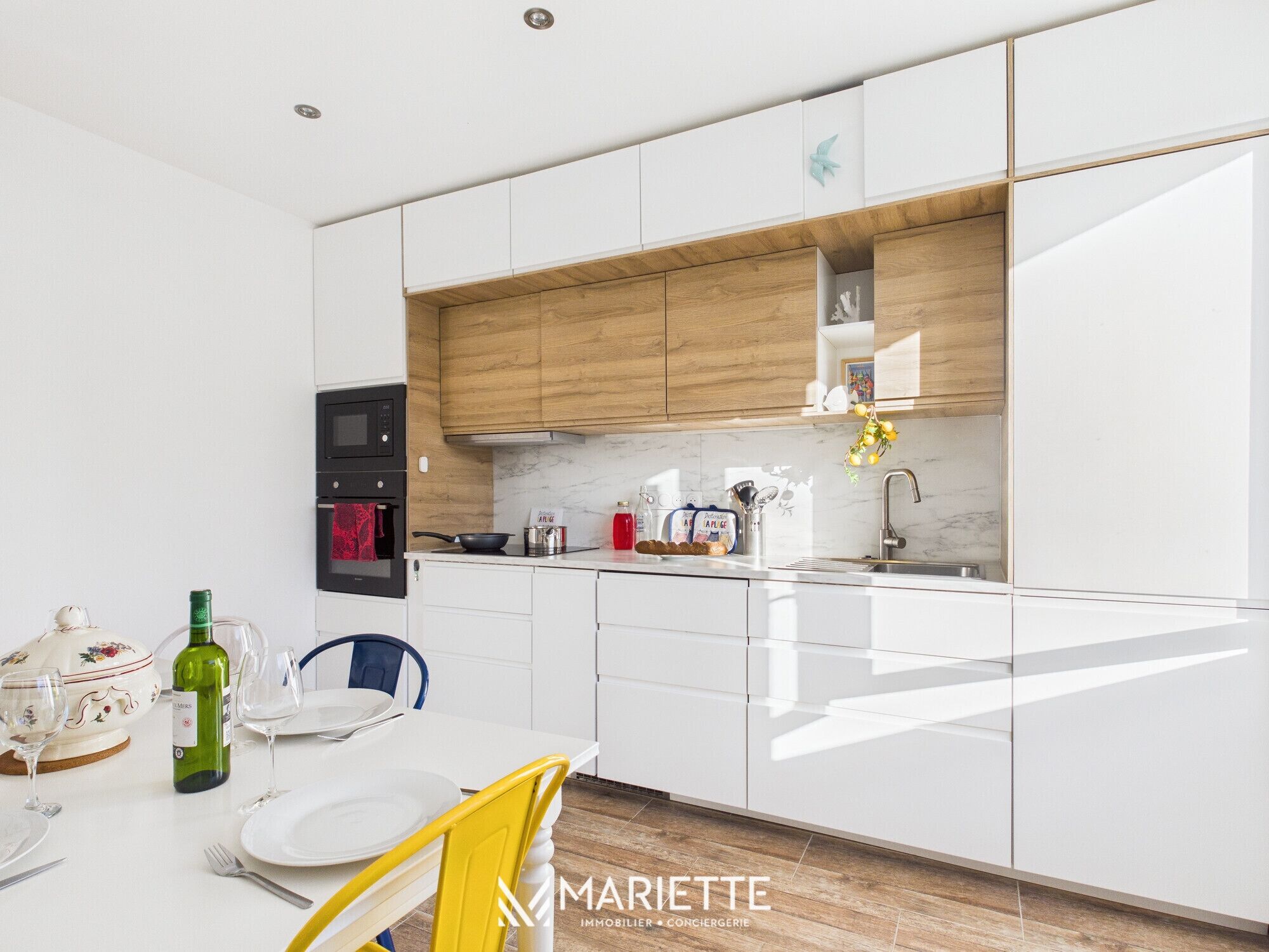 A modern kitchen with white cabinets, a wooden countertop, and a built-in oven.