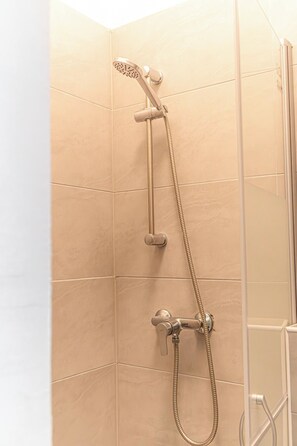 Eenvoudig appartement | Badkamer | Een douche, gratis toiletartikelen, een haardroger, handdoeken