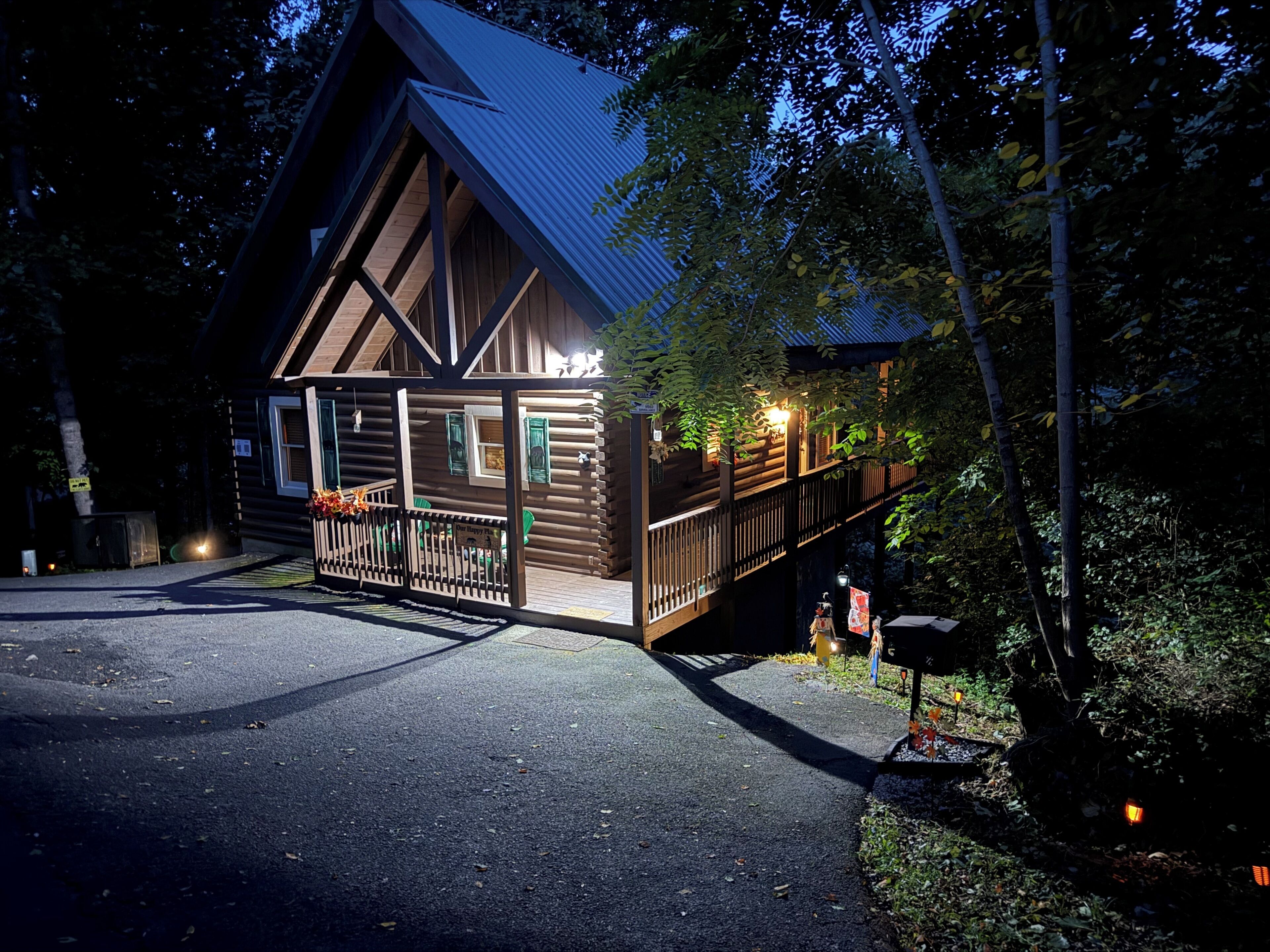 Une cabane en bois avec une véranda, une terrasse couverte et une boîte aux lettres.