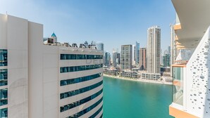 Un immeuble de grande hauteur à la façade incurvée, donnant sur une étendue d’eau et offrant une vue sur le paysage urbain.