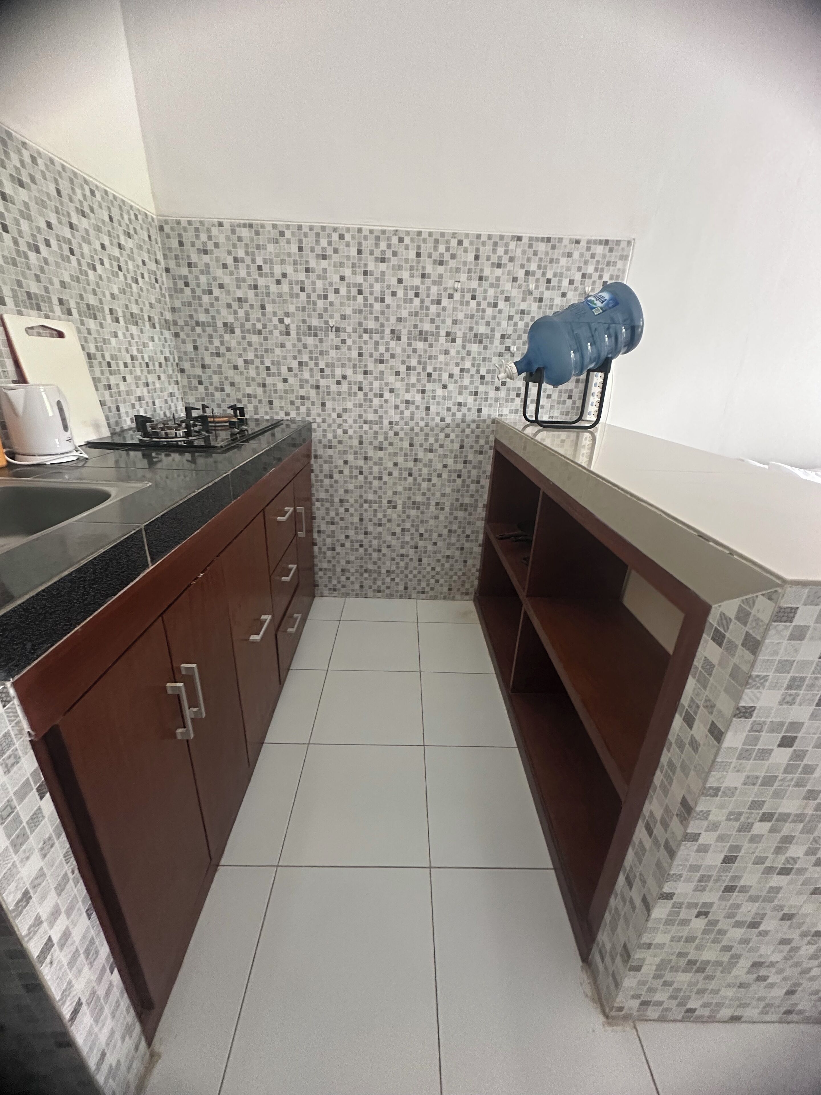Cozinha compacta com fogão a gás, pia e bancada.