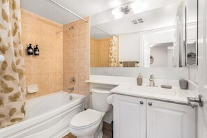 A bathroom with a bathtub, toilet, and sink.