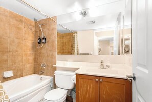 A bathroom with a bathtub, toilet, and shower. - Premier SkySuite 3BR | Horizon Views + Parking (Mississauga)