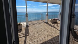 A balcony with a view of the sea, featuring a tiled floor and potted plants. - Suite Torre Azzurra B&B Rooftop Sea View (Follonica)