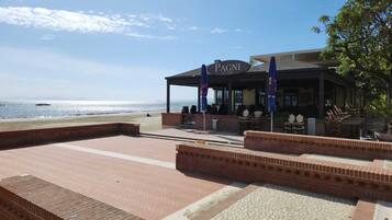 Un restaurante junto a la playa llamado PAGNI Ice Caff.