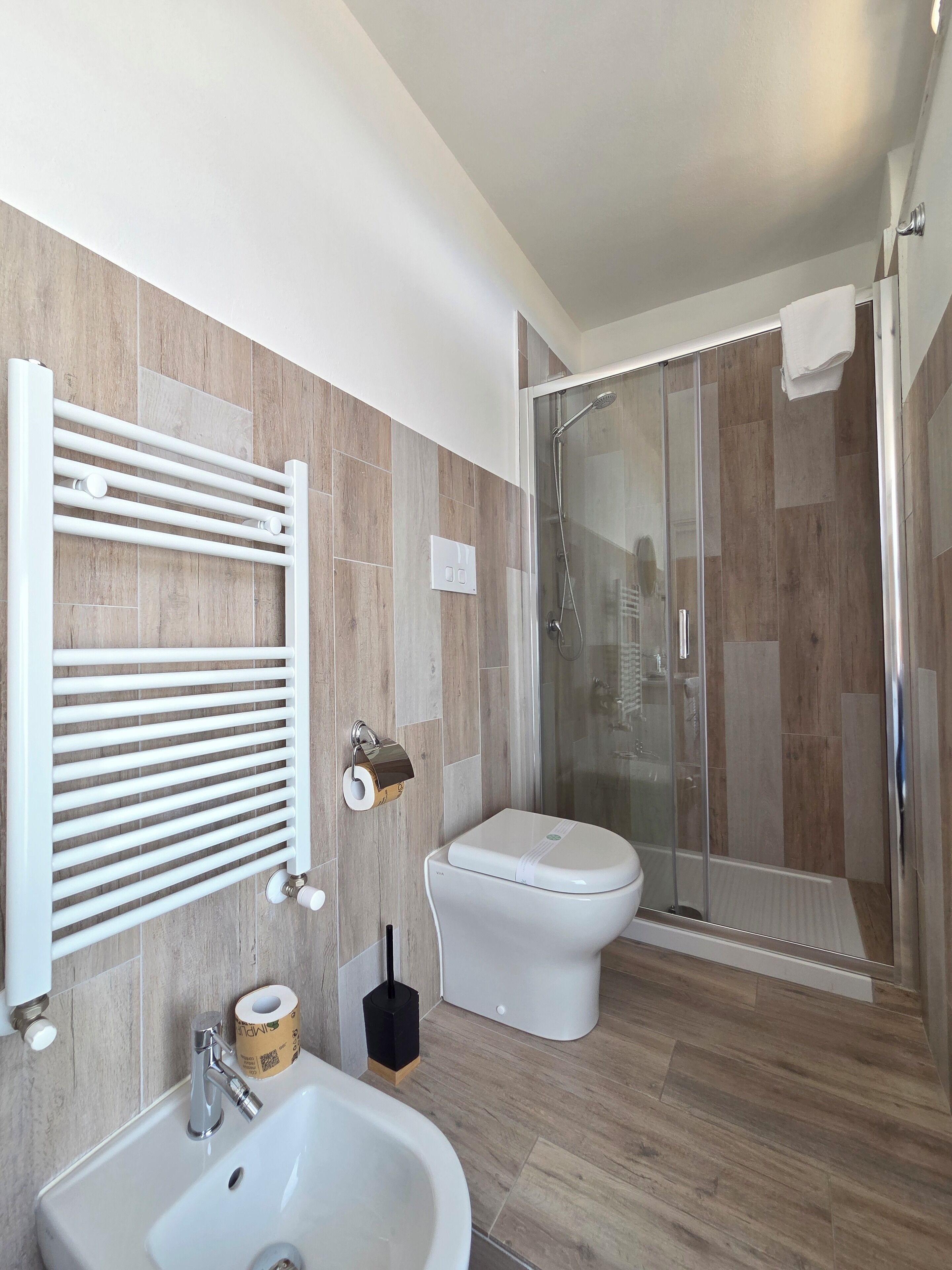 A modern bathroom with a toilet, sink, and shower.