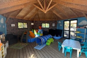 A children's play area with a slide, play structures, and a table with chairs. - Comfortable mobile home with terrace & plancha - Family campsite (Saint-Georges-d'Oléron)