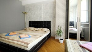 Une chambre à coucher avec un lit, une plante en pot et une fenêtre.