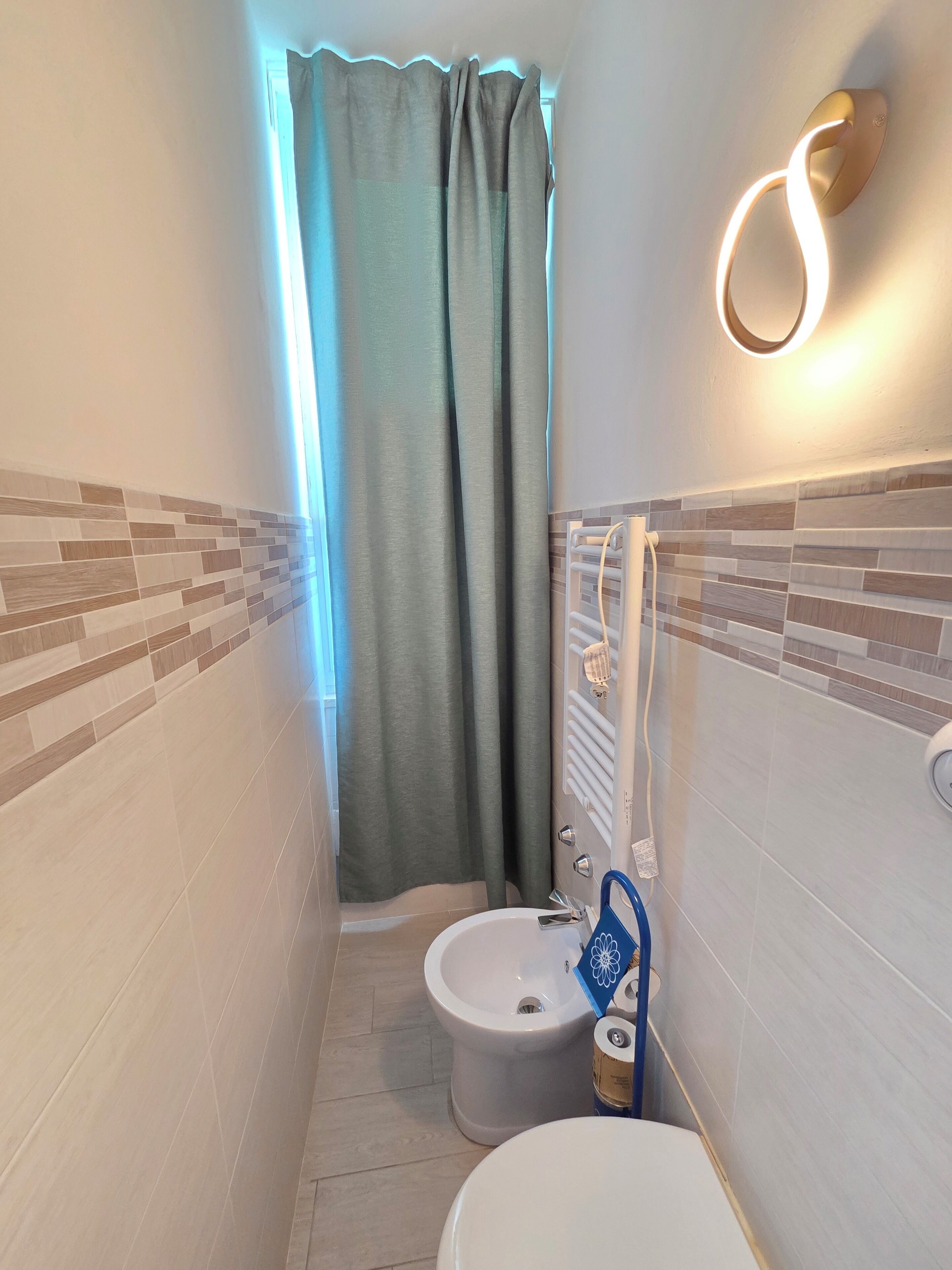 Une salle de bain équipée de toilettes, d’un bidet et d’un porte-serviettes.