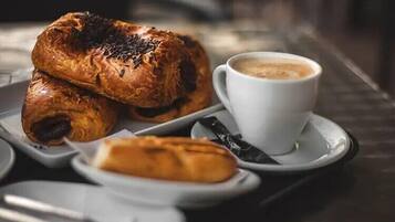 Una bandeja con pasteles y una taza de café sobre una mesa.