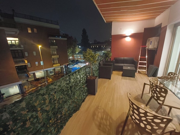 A rooftop terrace with a seating area, a pool, and a view of the cityscape at night. - Maya Casa (Rome)