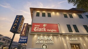Un edificio con letreros que indican 'Hotel Clark Heights' y 'Kanak Jewellers'.