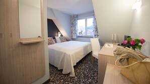 A bedroom with a bed, a desk, a chair, a mirror, and a window with curtains. - Condé RE-10, Germany (Stolpe auf Usedom)