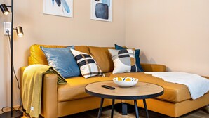 Ein modernes Wohnzimmer mit einer Couch, einem runden Couchtisch und einer Stehlampe.