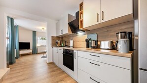 Eine moderne Küche mit Holzausstattung, einem Backofen und einer Kaffeemaschine.