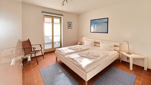 Un dormitorio moderno con una cama grande, un escritorio y una silla.