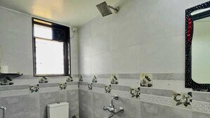 A bathroom with a toilet, a sink, and a shower. - JK Valley by Shree Stays (Mahabaleshwar)
