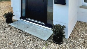 A modern building with a black door, a small porch, and a mailbox. - Newly Refurbished Bungalow- Large Garden- Parking (Ringwood)