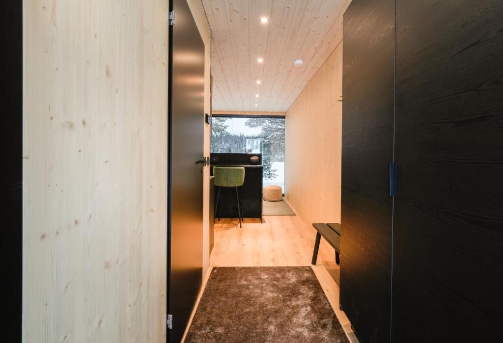 A hallway with wooden walls and a bench.