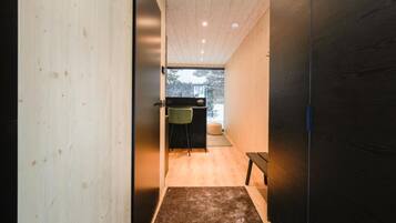 A hallway with wooden walls and a bench.