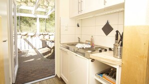 Une cuisine compacte dotée d’une cuisinière intégrée, d’un évier et d’un petit plan de travail.