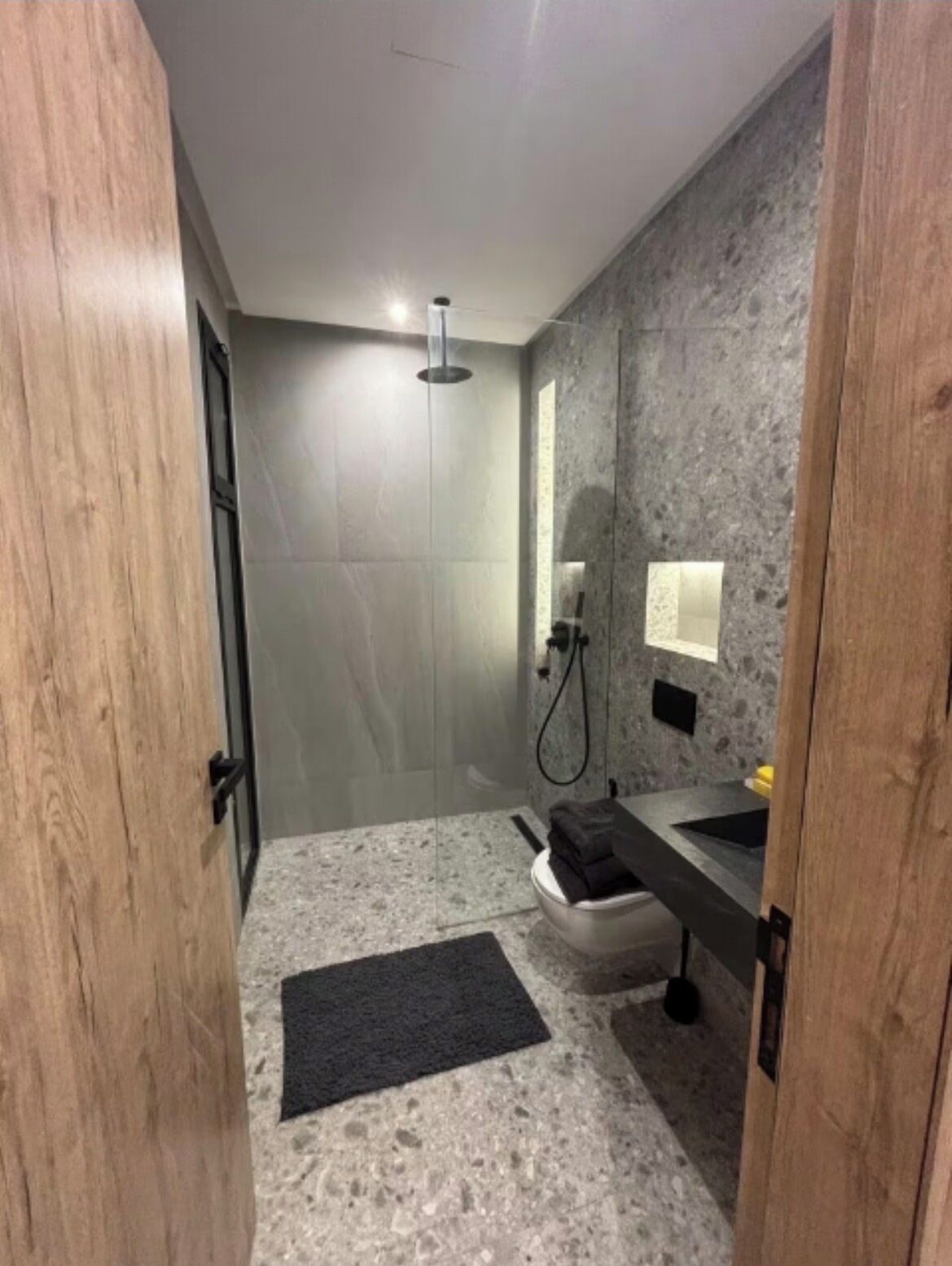 Ein modernes Badezimmer mit Dusche, Waschbecken und Toilette.