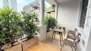 En balkon med plantekasser, et bord og stole.