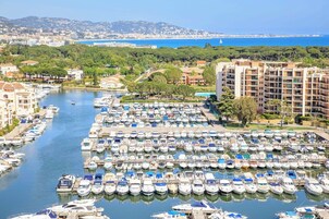 Un puerto deportivo con numerosas embarcaciones amarradas, rodeado de edificios residenciales y vegetación.