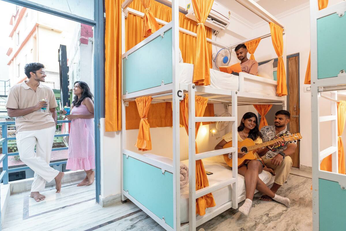 A room with bunk beds, a fan, and a window.
